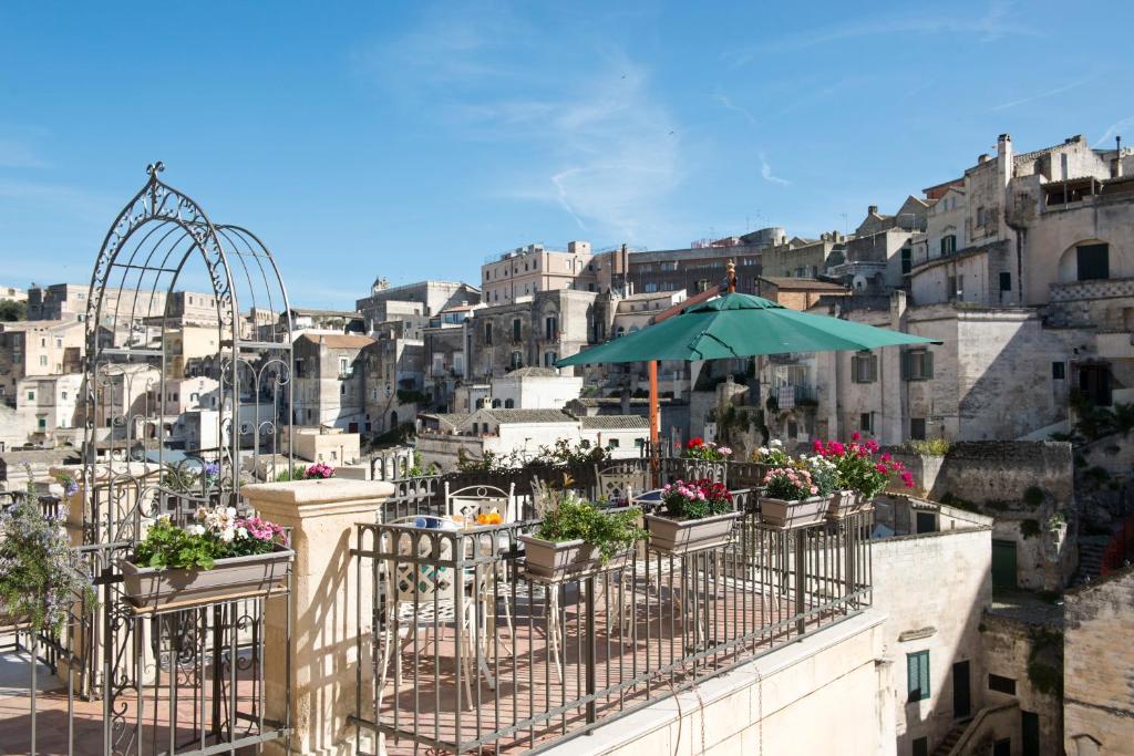 a balcony with a table and an umbrella at Sassisuite in Matera