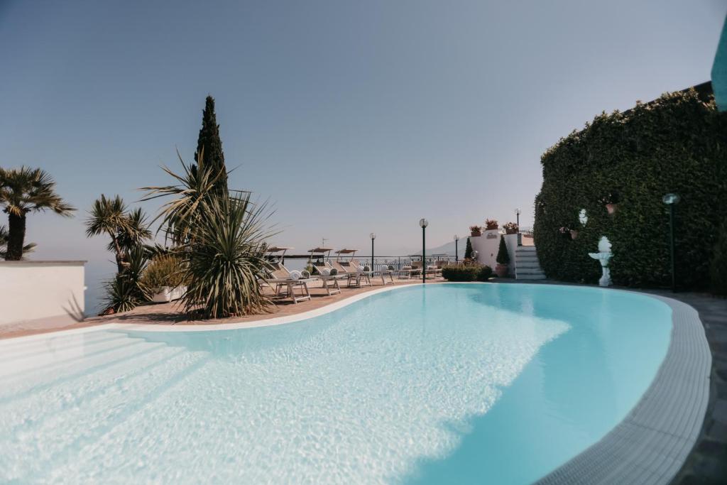 - une piscine dans un complexe avec des chaises et des arbres dans l'établissement Villa Bianca Sorrento, à Sorrente