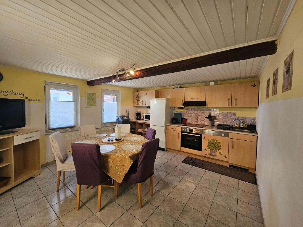 a kitchen with a table and chairs and a kitchen with at Fewo-O3-4-6-Personen-23km-bis-Frankfurt-Nord in Ober-Mörlen