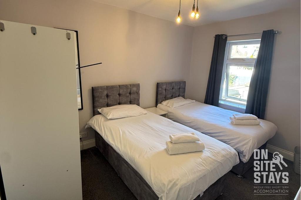 Dos camas una al lado de la otra en un dormitorio. en OnSiteStays - 4 bedroom house with 2 bathrooms, en Welling