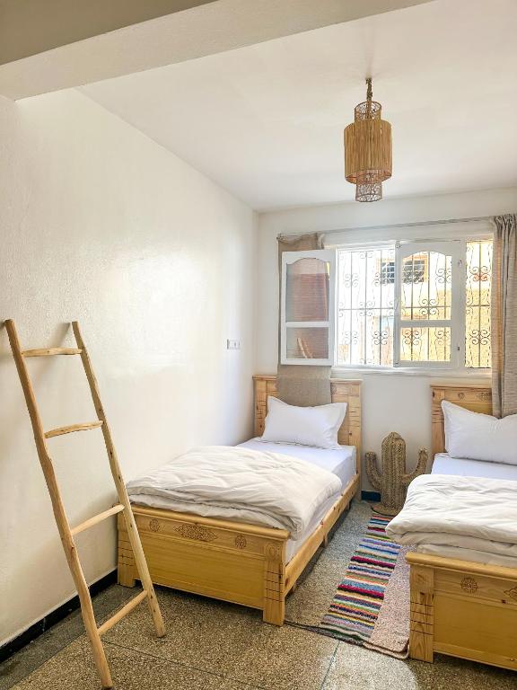 two beds in a room with a ladder at Surf and Stay Anza - Surf Territory in Agadir
