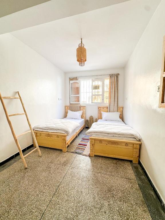 a room with two beds and a window at Surf and Stay Anza - Surf Territory in Agadir