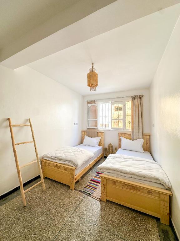 two beds in a room with a ladder at Surf and Stay Anza - Surf Territory in Agadir