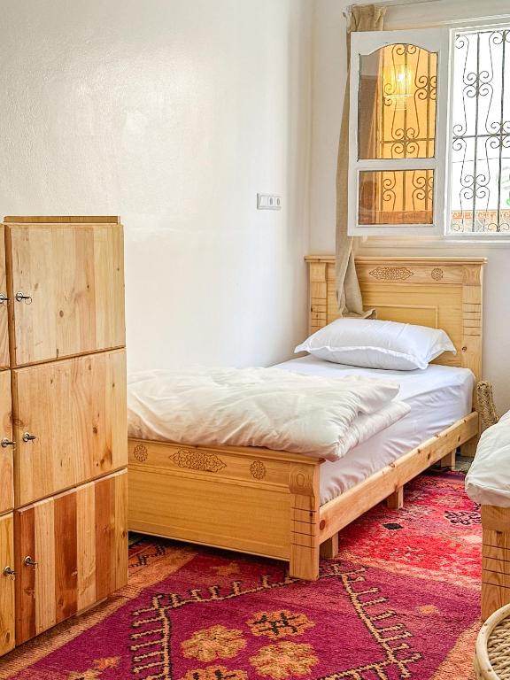 a bedroom with a bed and a dresser and a window at Surf and Stay Anza - Surf Territory in Agadir