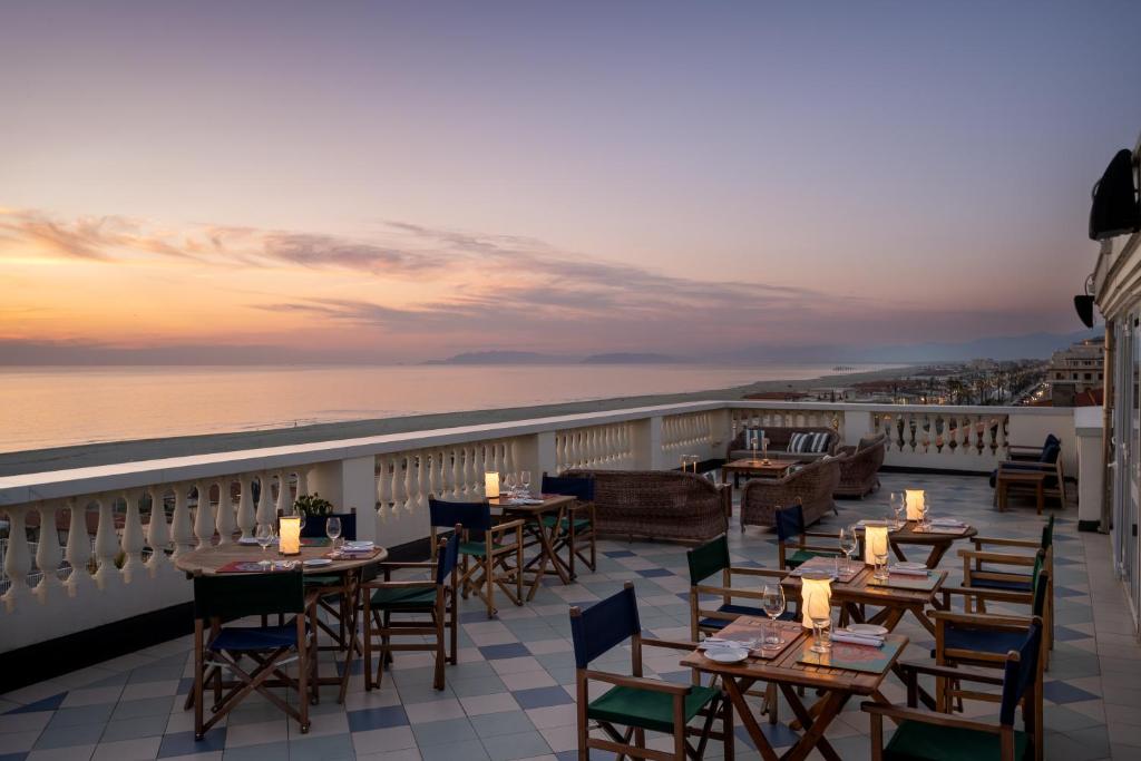 a restaurant with tables and chairs on a balcony at Palace Hotel in Viareggio