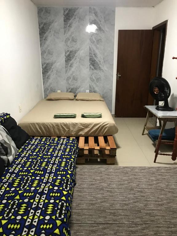 a bedroom with a bed and a table in it at Espaço Baobá Suítes Confortáveis in Camboriú