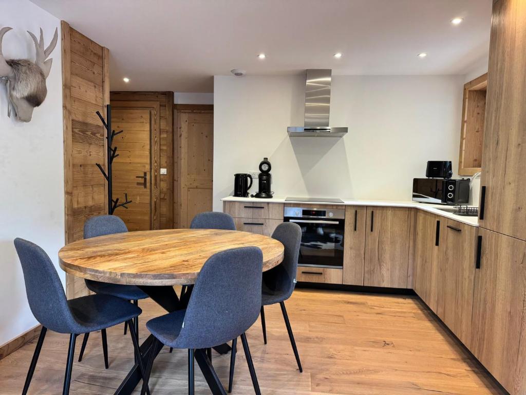 a kitchen with a wooden table and blue chairs at Appartement cosy 3 pièces, pied des pistes, parking, Pralognan - FR-1-464-242 in Pralognan-la-Vanoise