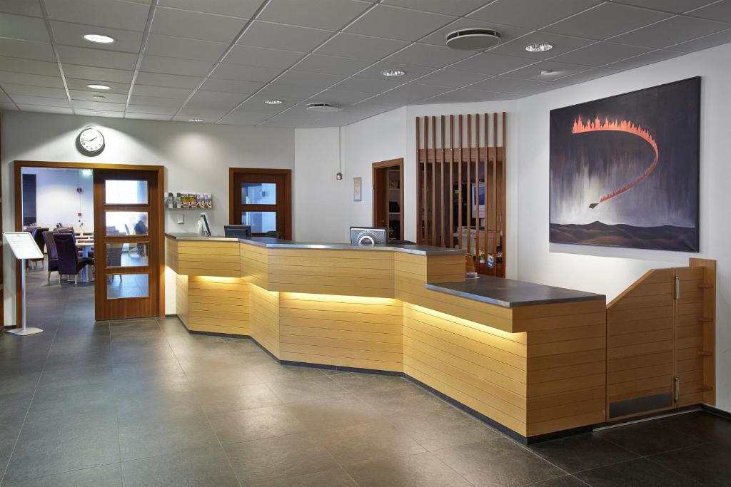 a lobby with a waiting room with wooden counters at Hotel Cabin in Reykjavík