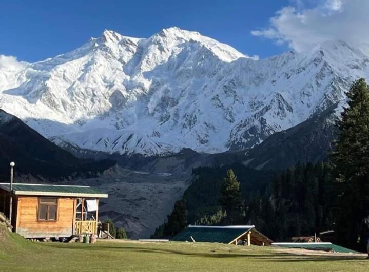 a house in front of a snow covered mountain at Fairy meadows BroadView Hotel in Tato