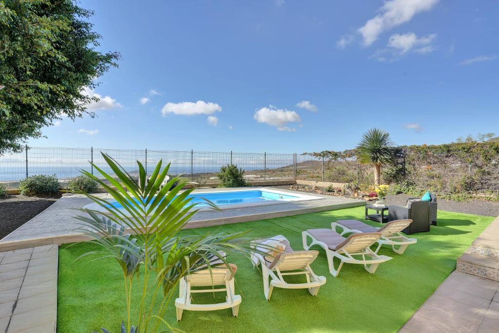 patio z krzesłami, basenem i oceanem w obiekcie Apartment Private Heated Pool w mieście El Draguito