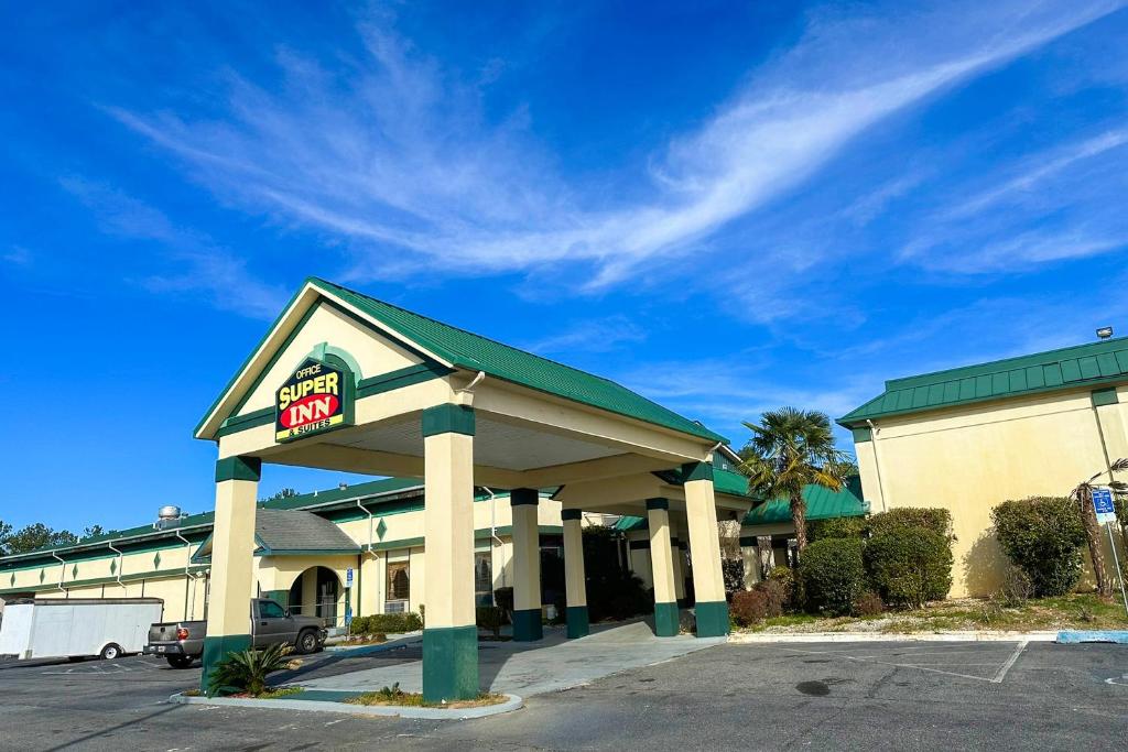 a gas station with a for sale sign in a parking lot at Super Inn & Suites by OYO Milledgeville in Milledgeville