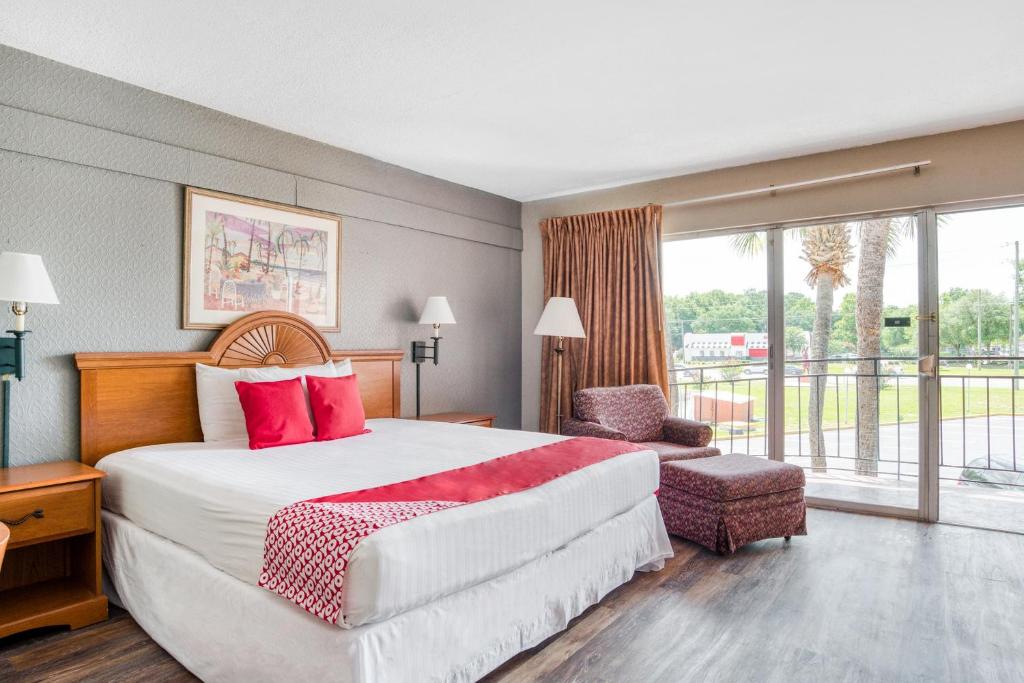 a hotel room with a large bed and a balcony at OYO Hotel Mustang Silver Spring FL in Silver Springs