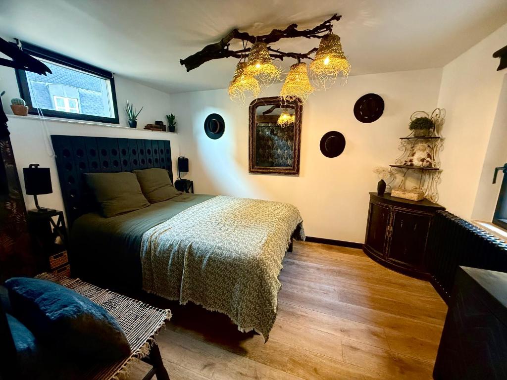 een slaapkamer met een bed en een spiegel aan de muur bij L'Evidence, appartement authentique - Epernay in Épernay