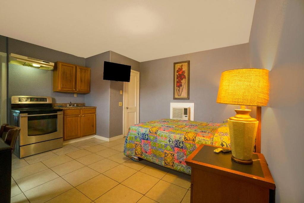 a bedroom with a bed and a table with a lamp at Texana Inn Edna By OYO in Edna