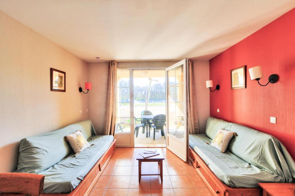 un salon avec deux canapés et un balcon dans l'établissement La résidence du Lac - maeva Home - Appartement 2 pièces 5 personnes - Sélection MAE-4111, à Monflanquin