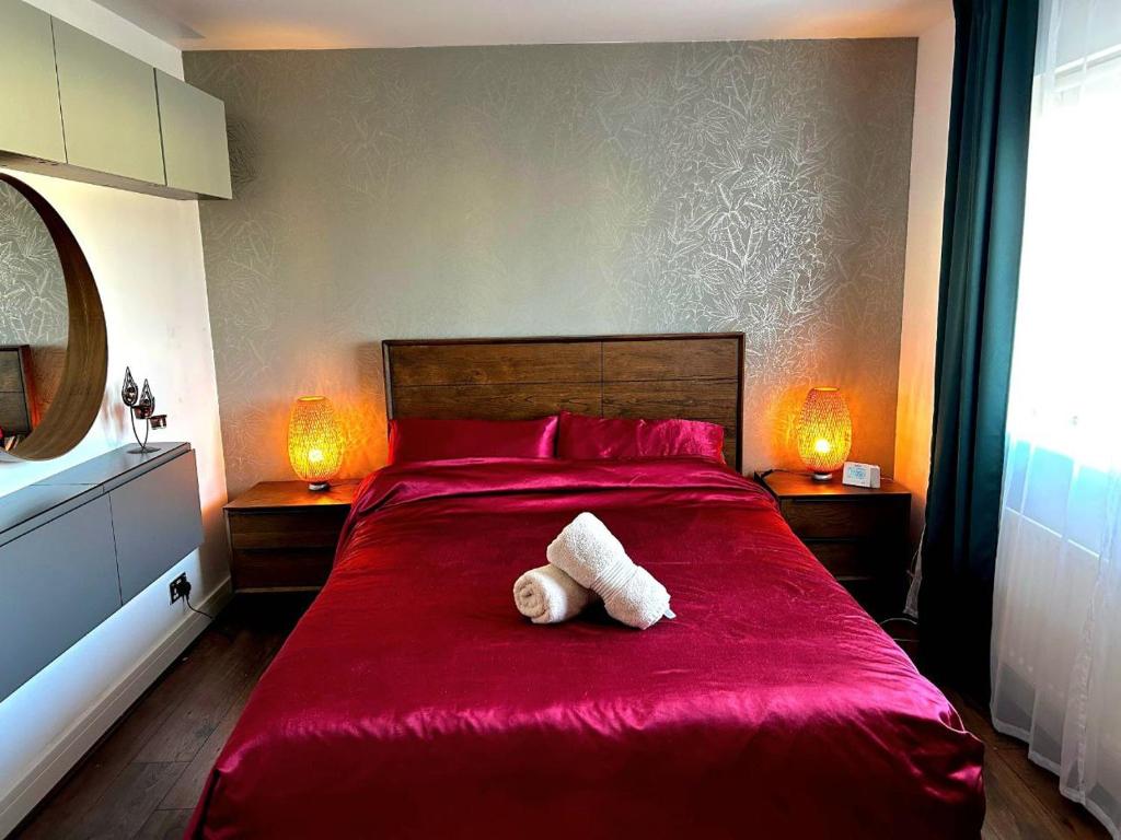 a bedroom with a red bed with a stuffed animal on it at Modern Duplex in Greystones in Na Clocha Liatha