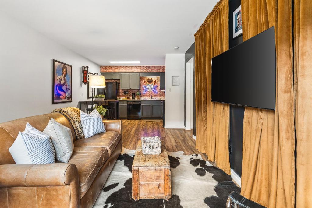 a living room with a couch and a flat screen tv at Cozy Condo by Music Row Walk to Restaurants and Bars in Nashville