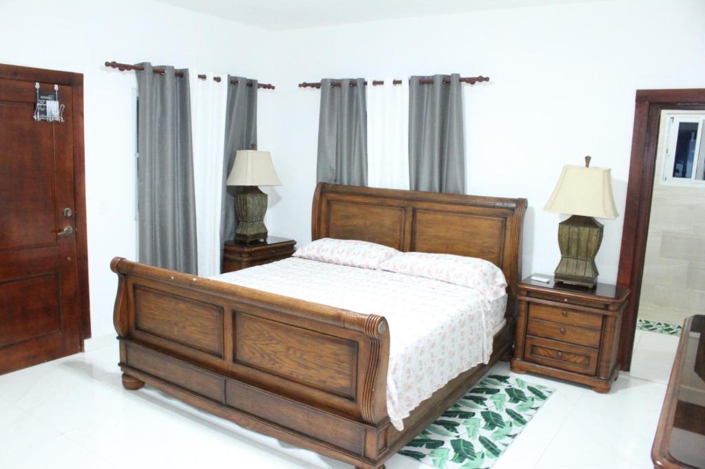 キャバレテにあるVilla luxury Cabareteのベッドルーム1室(木製ベッド1台、ナイトスタンド2台付)