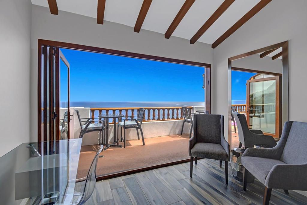 a living room with chairs and a balcony with a view at H246 - Hamilton Cove Villa 2-46 in Avalon
