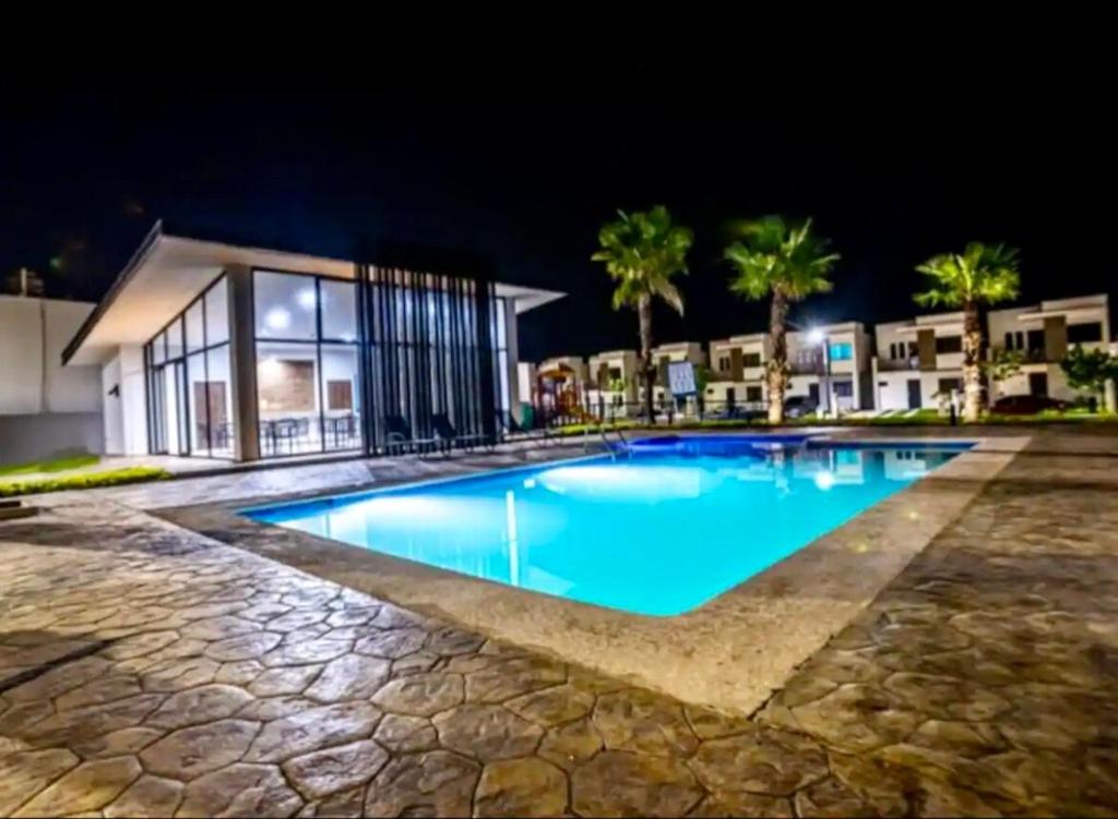 a swimming pool at night in front of a building at Casa exclusiva con alberca en privada Cerca de Galería in Mazatlán