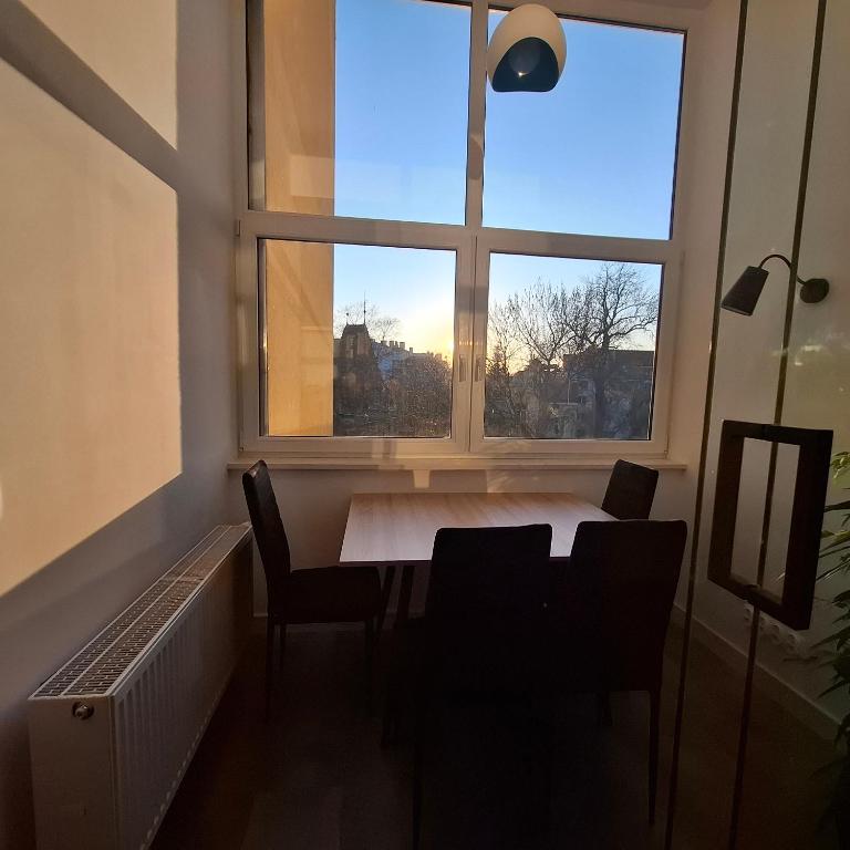 a dining room with a table and a large window at Century Apartment in Wrocław