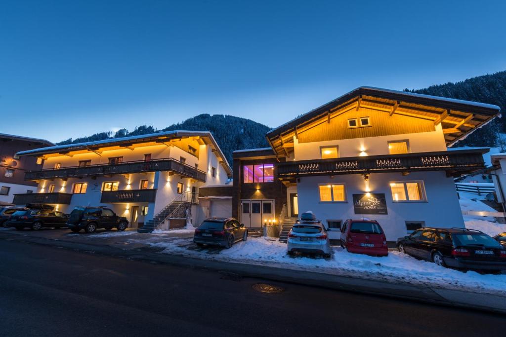 un paio di edifici con auto parcheggiate di fronte a loro di Chalet Alpinhome a Tux