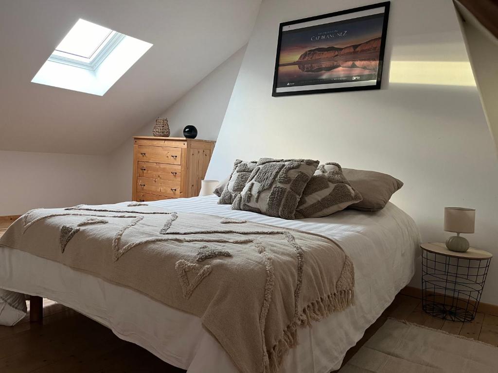 une chambre avec un lit et un tableau au mur dans l'établissement La maison de la Terre d Opale, à Saint-Inglevert