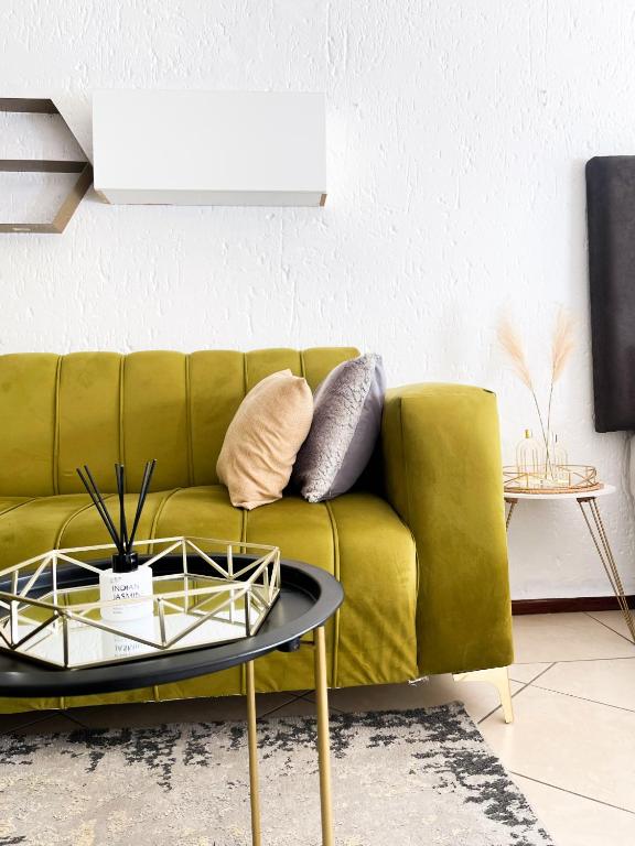a green couch in a living room with a table at Cozy Corner in Sandton