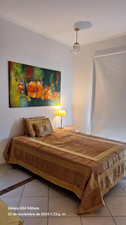 ein Schlafzimmer mit einem großen Holzbett mit einem Gemälde an der Wand in der Unterkunft Monoambiente en Costanera Posadas Misiones in Posadas