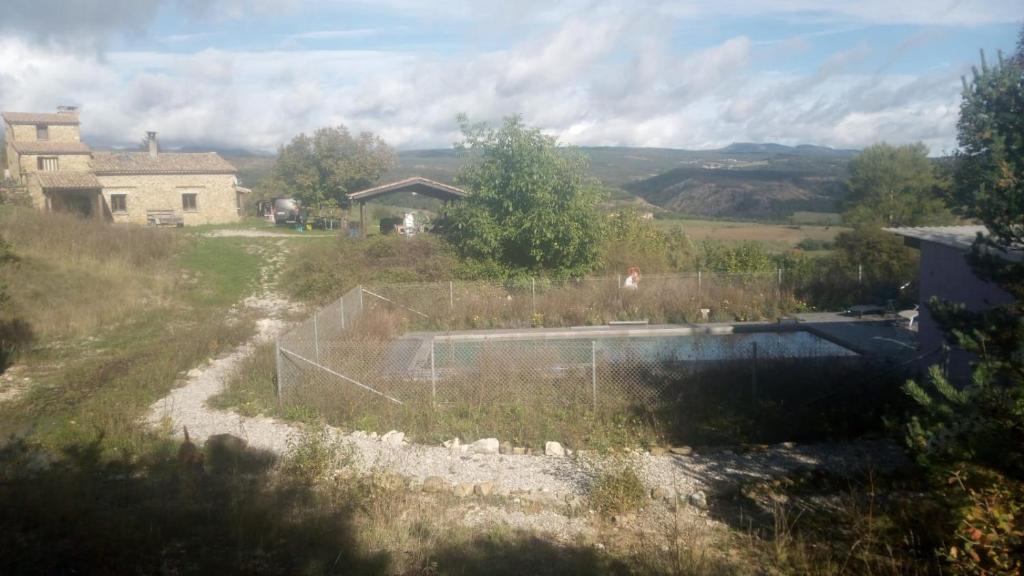 - une vue sur une cour avec une clôture et un étang dans l'établissement La vie en Rosans - The upperhouse, à Saint-André-de-Rosans