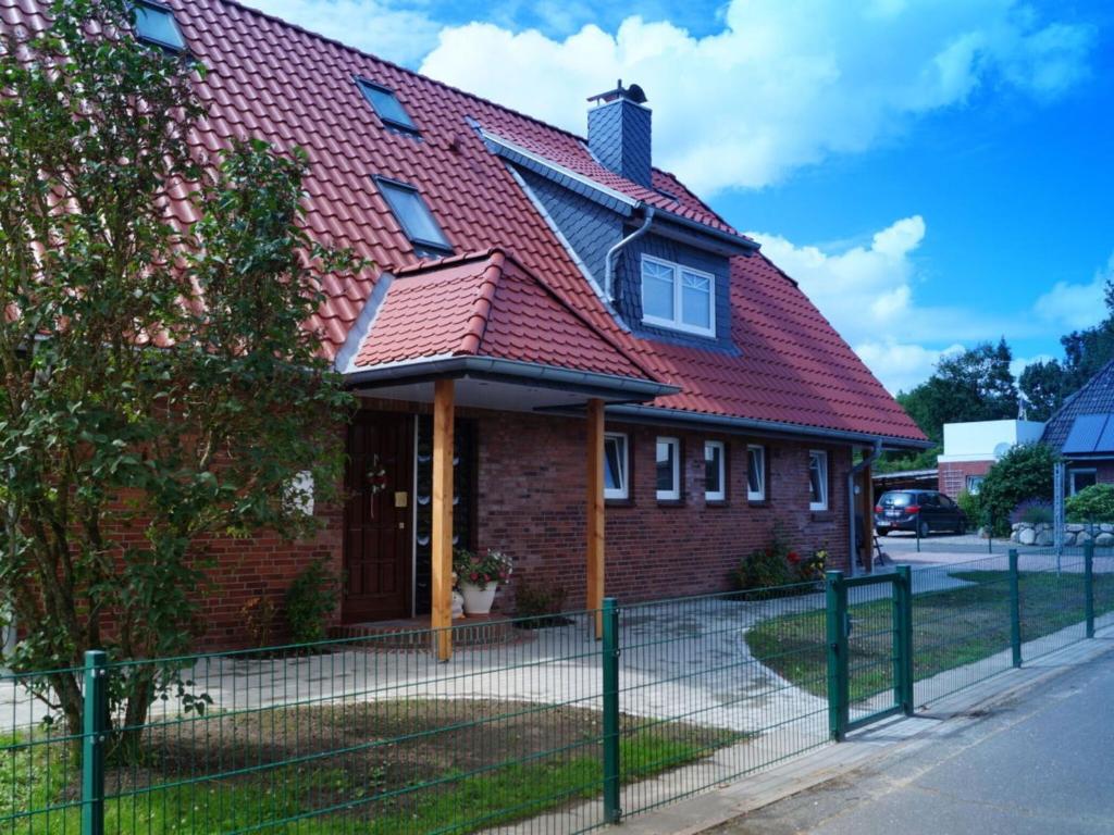 una casa con techo rojo y valla en Holiday apartment Utholm, en Tönning
