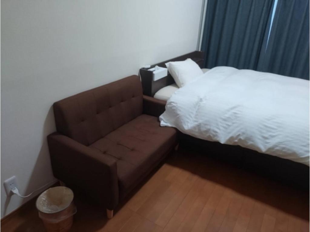 a bedroom with a couch next to a bed at IshinomakiYado - Vacation STAY 71853v in Ishinomaki