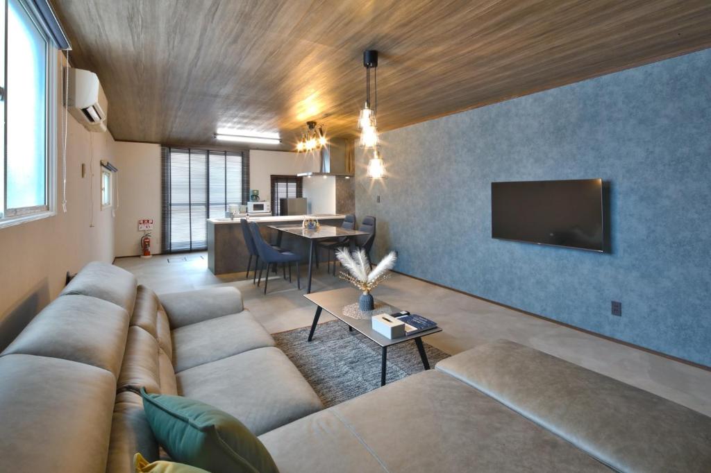 a living room with a couch and a tv at GUESTHOUSE LE REPOS - Vacation STAY 18746 in Abashiri
