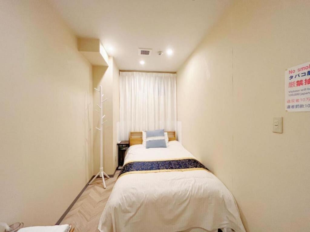 ein kleines Schlafzimmer mit einem Bett in einem Zimmer in der Unterkunft MIYAVI hotel - Vacation STAY 75579v in Tokio