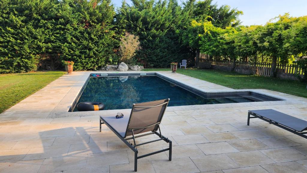 - une piscine avec une chaise et une table dans l'établissement Luboregard, à Cheval-Blanc