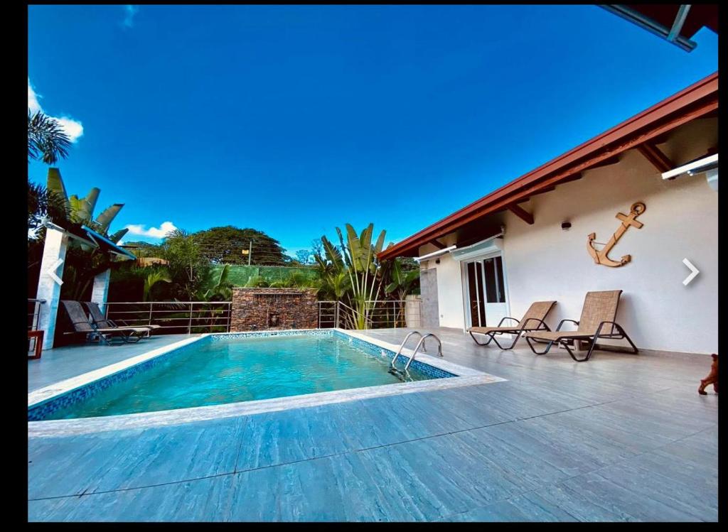 a swimming pool in front of a house at villa de luxe super equipee in El Limón