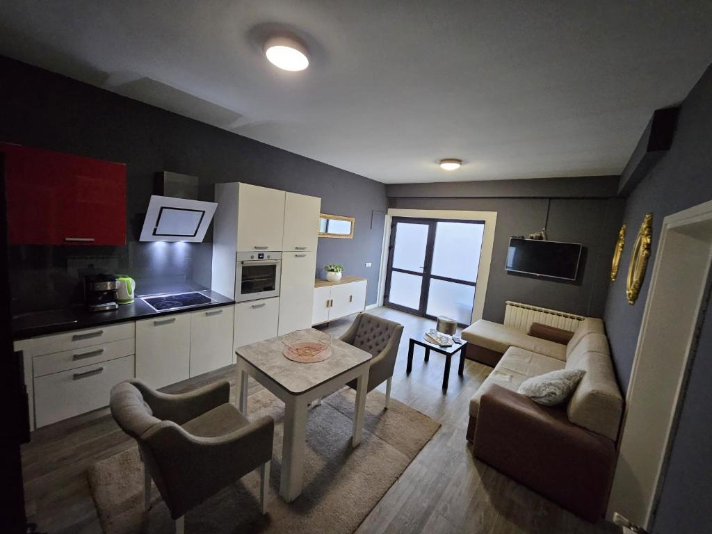 a kitchen and living room with a table and a couch at Apartman Green Hill in Zagreb