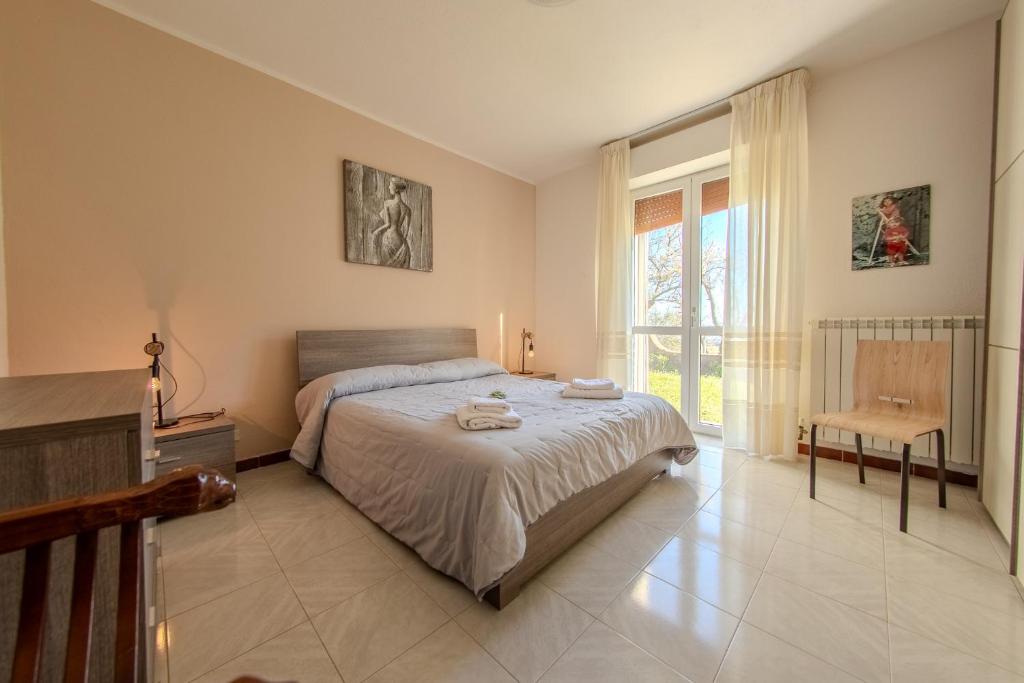 a bedroom with a bed and a chair and a window at Villa Maddalena in Scala