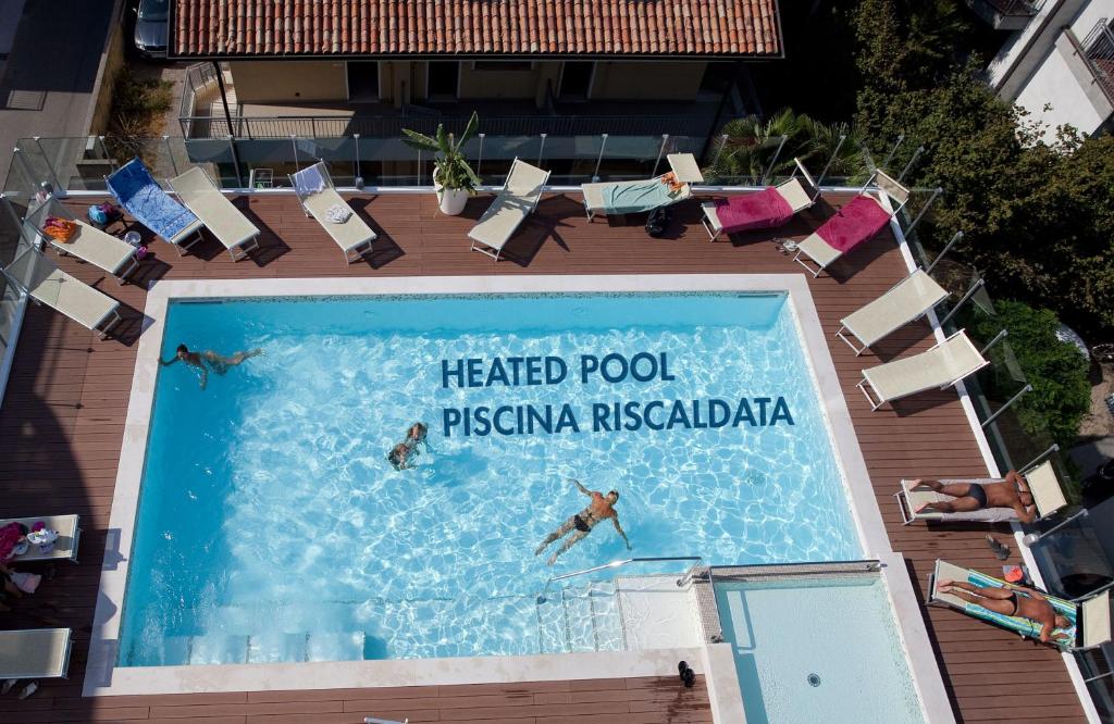 people swimming in a swimming pool at a resort at Hotel Tropical in Lido di Jesolo