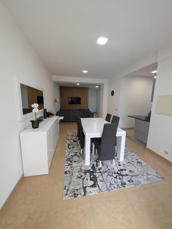 a living room with a white table and chairs at Apartamento Sol e Mar in Fão