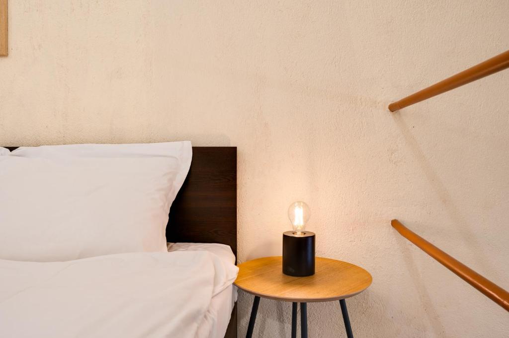 Una vela sentada en una mesa junto a una cama en Cozy Nest Charming Loft in the heart of Varna, en Varna