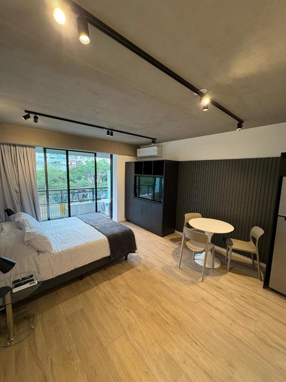 a bedroom with a bed and a table and chairs at HUB Apart Nuñez in Buenos Aires