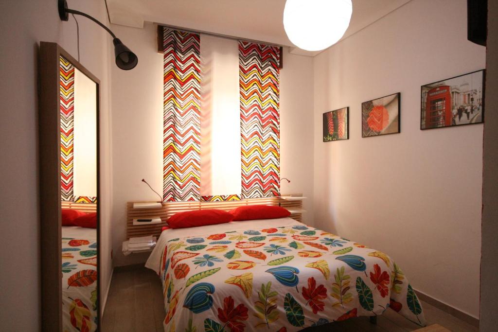 1 dormitorio con 1 cama con una manta colorida en B&B Santiago, en Gela