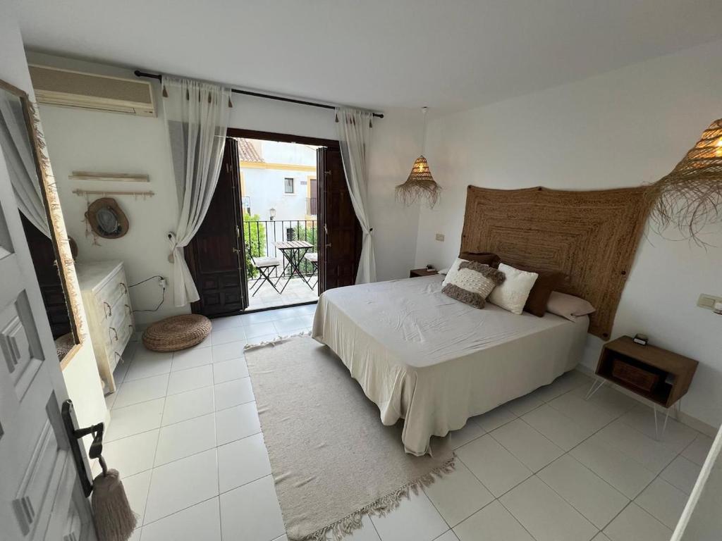 een witte slaapkamer met een bed en een balkon bij Moderno dúplex Coastal Style in Playas de Vera
