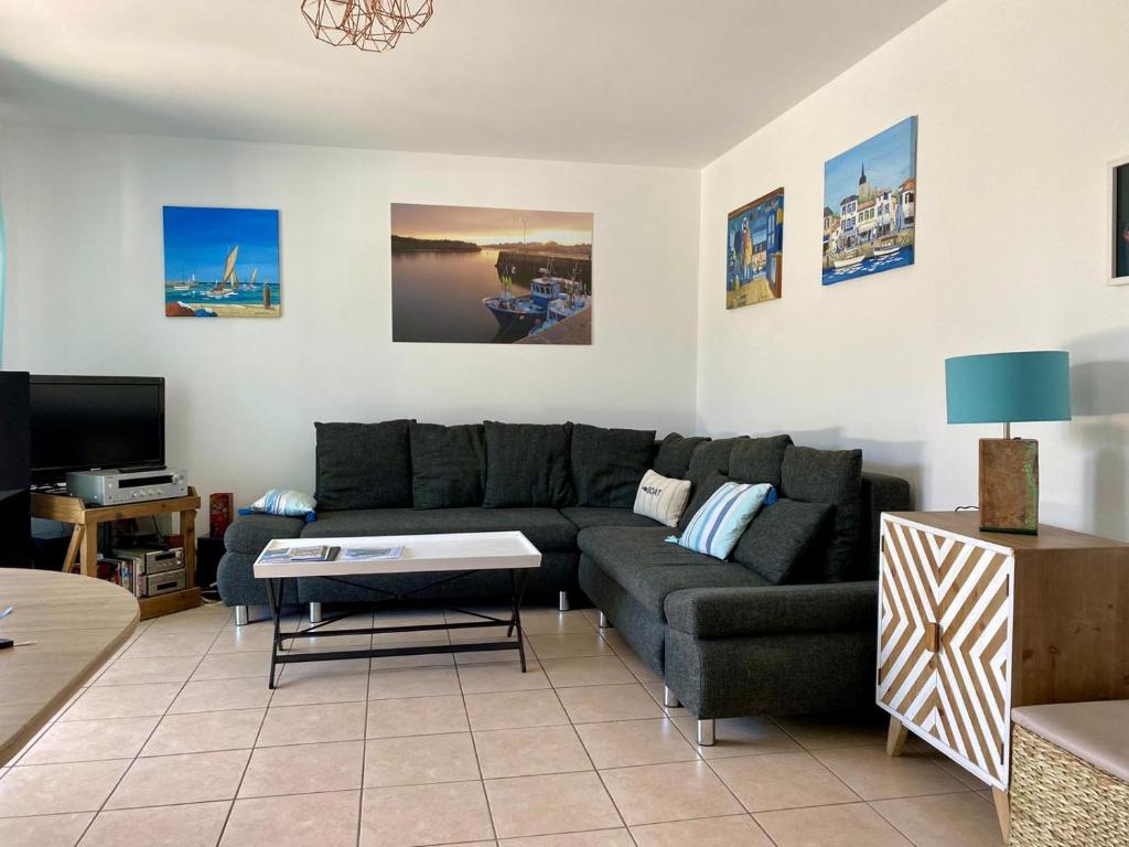 un salon avec un canapé et une télévision dans l'établissement Joli appartement proche mer, à Saint-Gilles-Croix-de-Vie