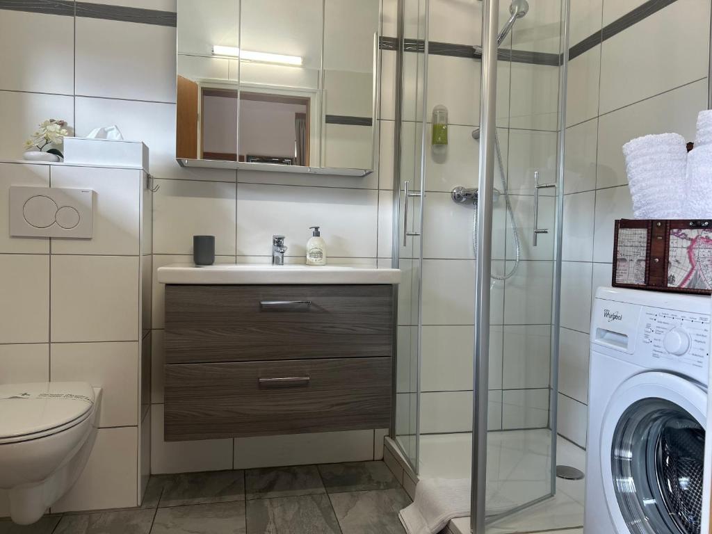 łazienka z umywalką i pralką w obiekcie Warmbad Apartments w Villach