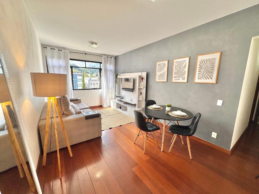 un soggiorno con un tavolo e un divano di Apartamento Compacto e Confortável no Centro de Nova Friburgo a Nova Friburgo