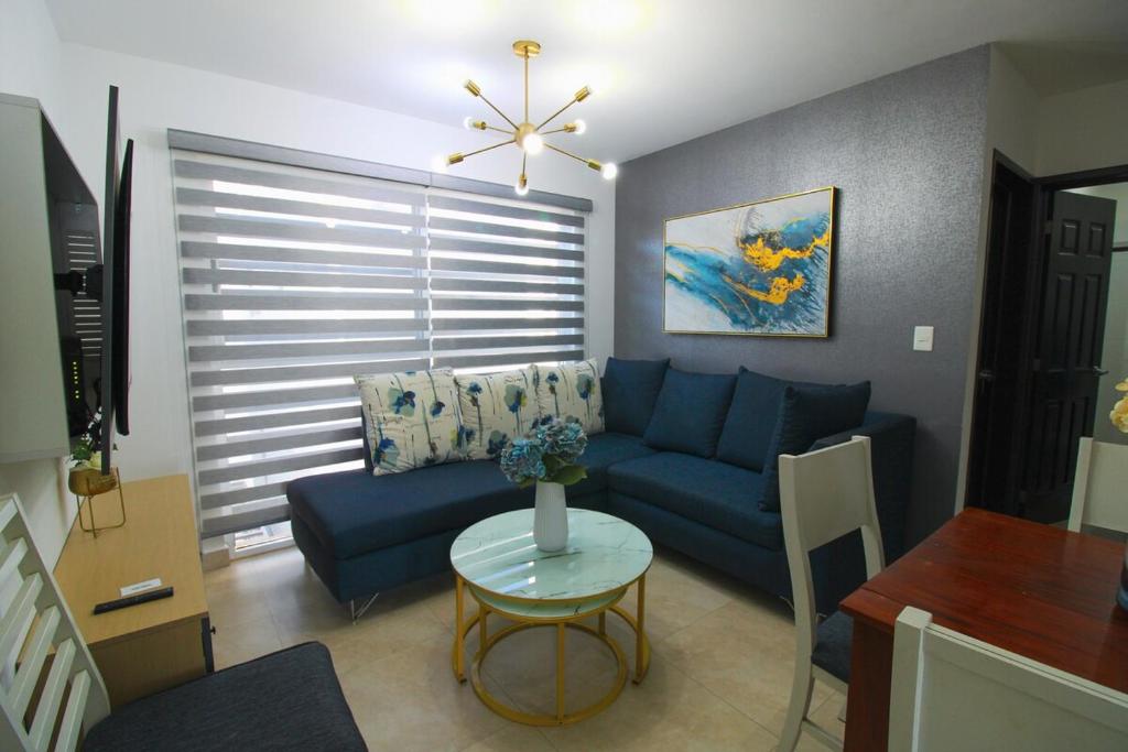 een woonkamer met een blauwe bank en een tafel bij Departamento Close to Beach - Azul pacifico in Mazatlán
