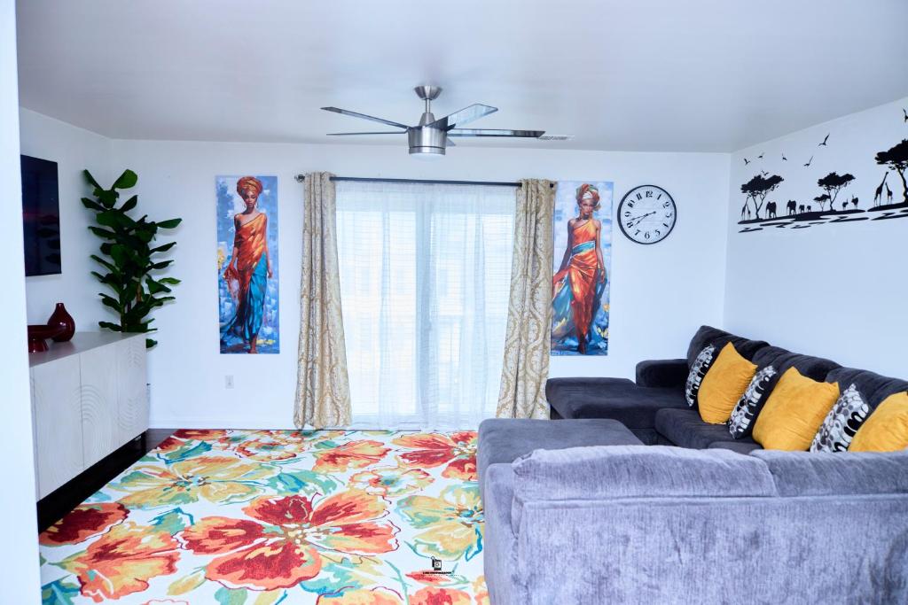 a living room with a couch and a clock at Beautifully Designed & Spacious Apartment in Newark 10mins from EWR Airport, Close to NYC and Beth Israel Hospital in Newark