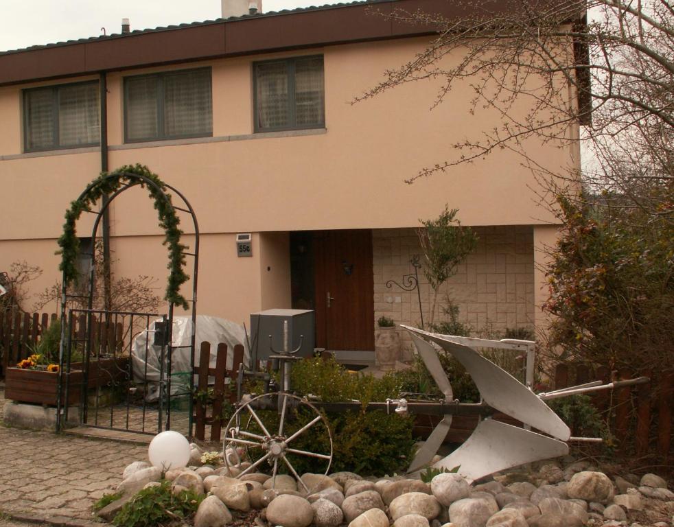 a house with an umbrella and a wheel in front of it at Villa Lavendel in Gondiswil